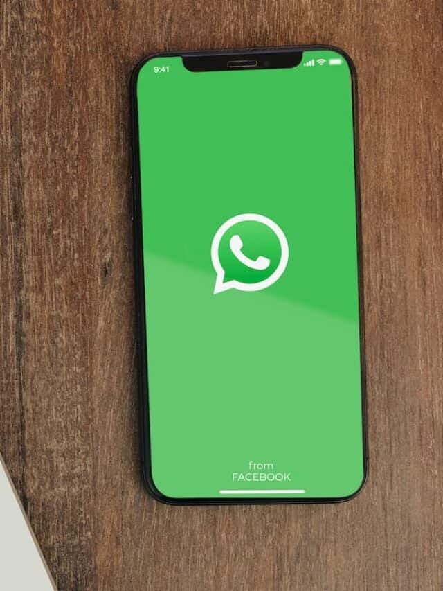 Aplicativo do WhatsApp em celular ao lado de notebook