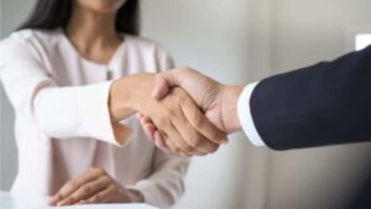 Uma mulher apertando a mão de um homem, como se estivessem entrando em acordo sobre algo