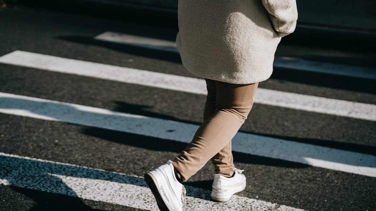 Pessoa caminhando em faixa de pedestres
