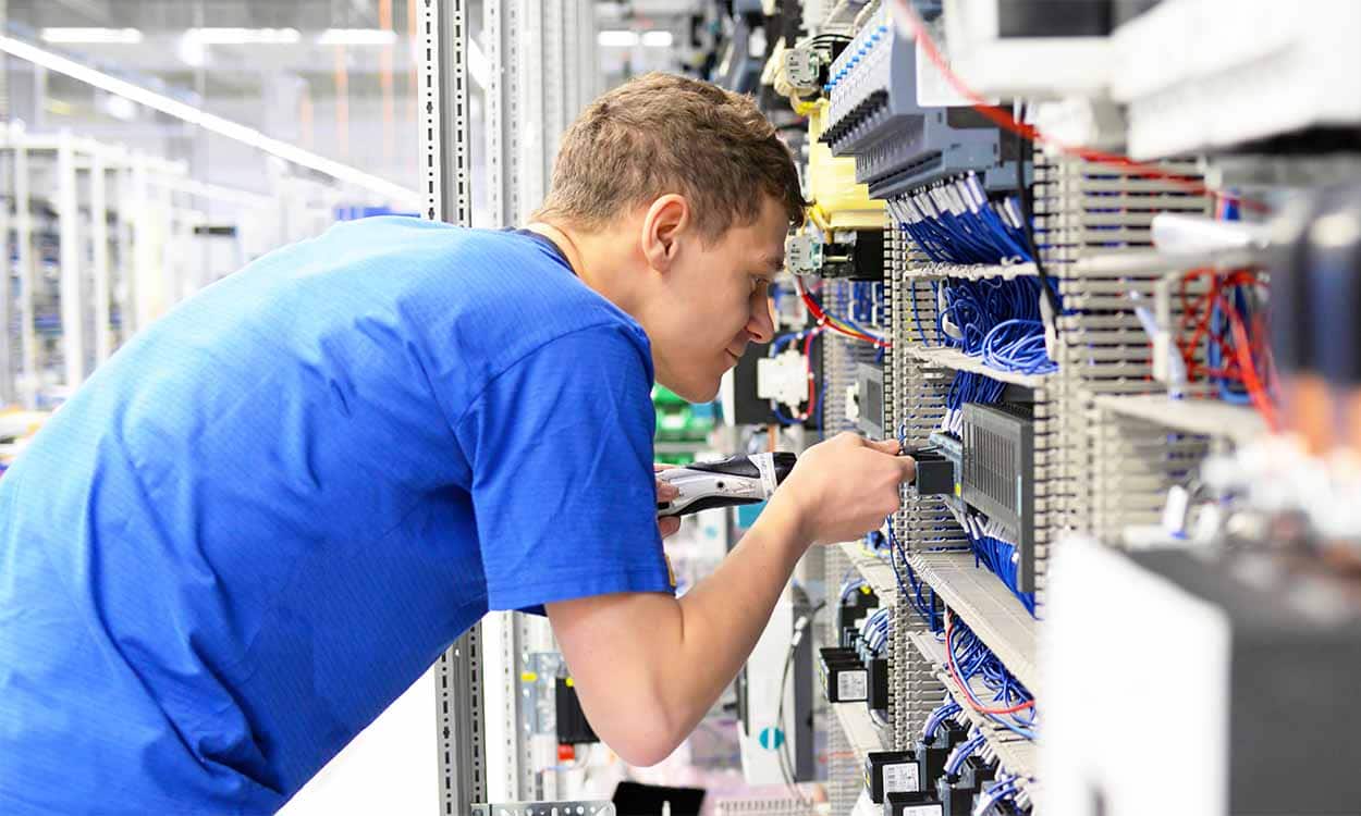 garotos mexendo nos fios de equipamento que parece um servidor