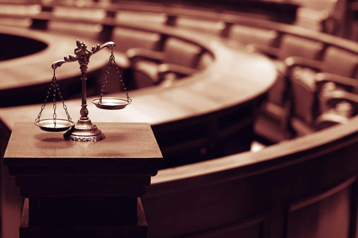 Tribunal de justiça, com balança sobre bancada