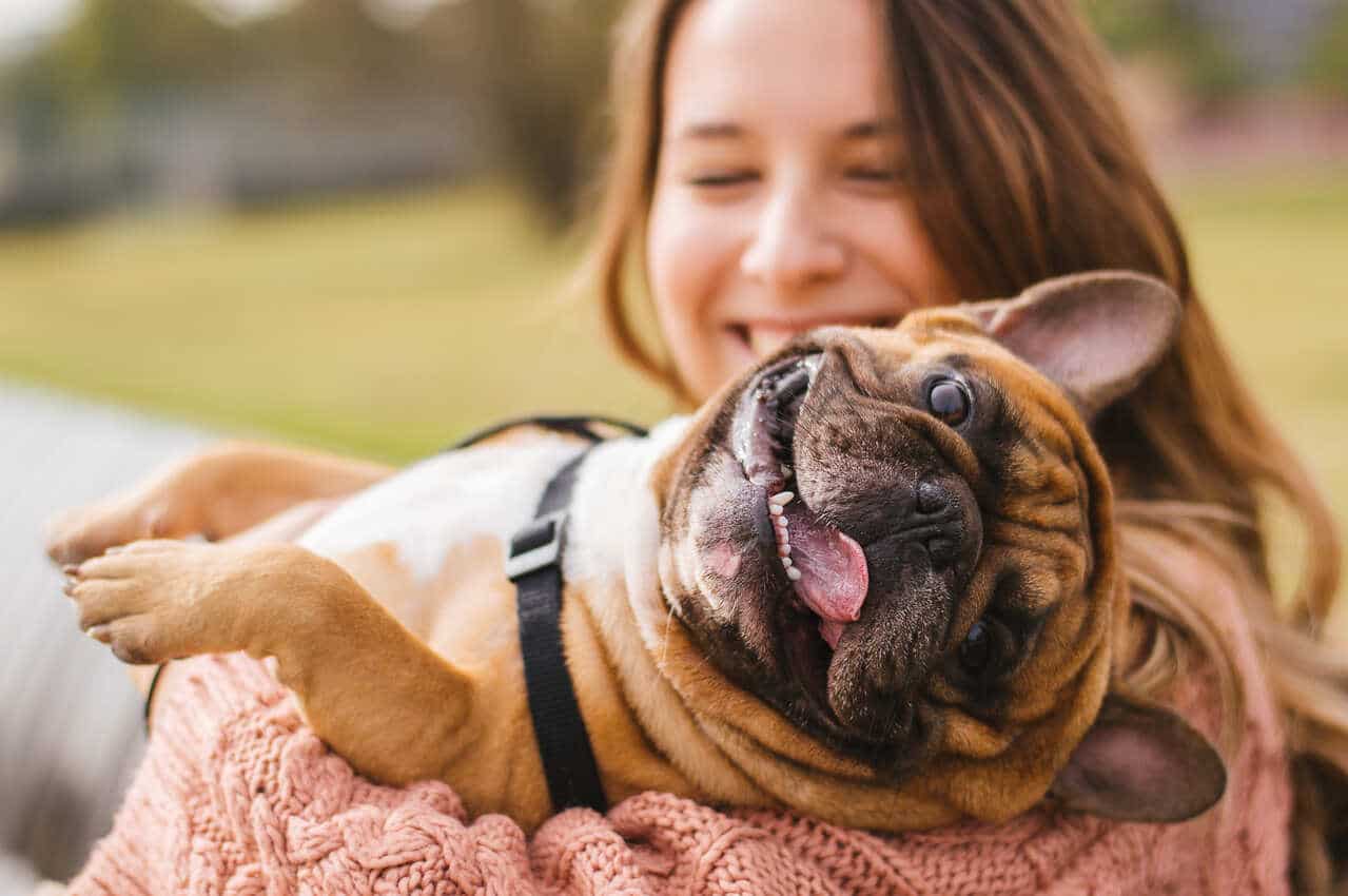 Imagem de uma mulher segurando um cachorro