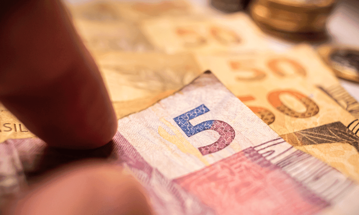 estatais pessoa pegando nota de 5 reais déficit zero brasil cortes