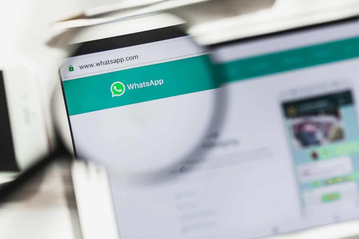 Logo do WhatsApp aproximado com uma lupa, em um computador.
