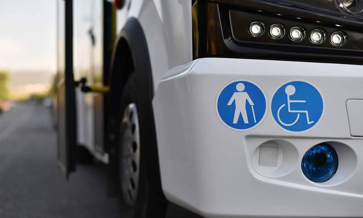 Ônibus branco parado com a porta aberta
