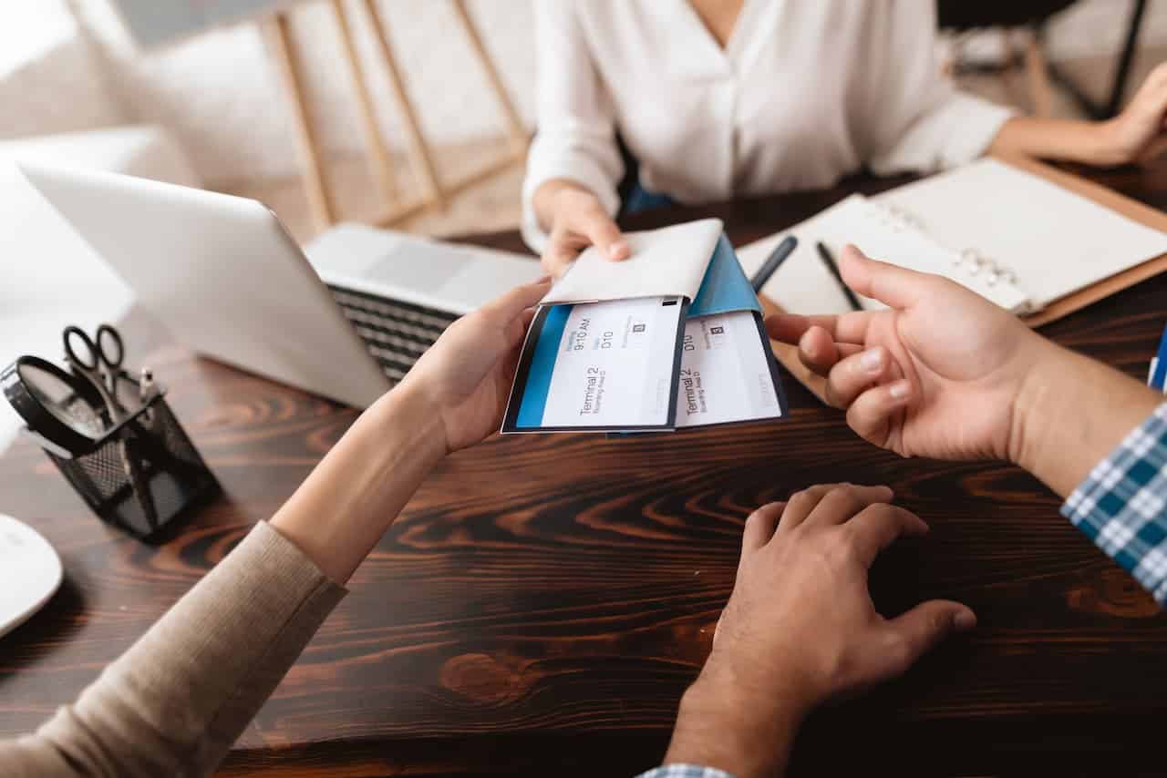 Agência de viagem entregando as passagens para um casal.
