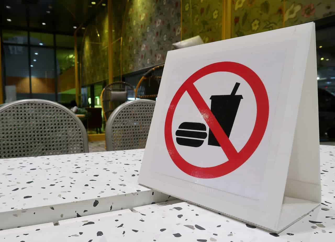 Placa de alimentos proibidos em cima de uma mesa