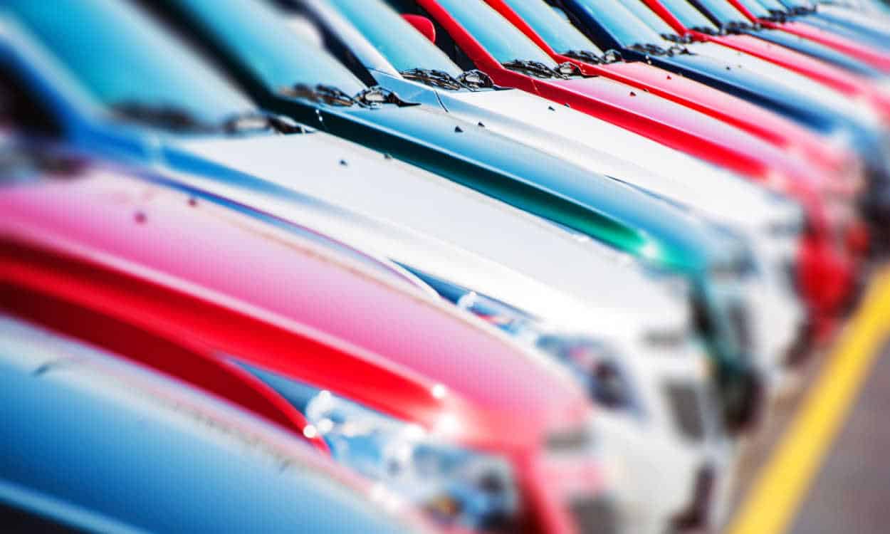 Vários carros parados um ao lado do outro em um estacionamento.