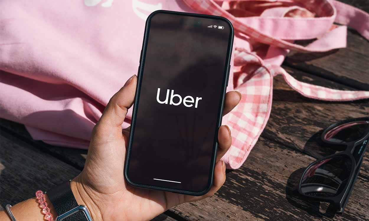 Mão segurando celular com app da Uber