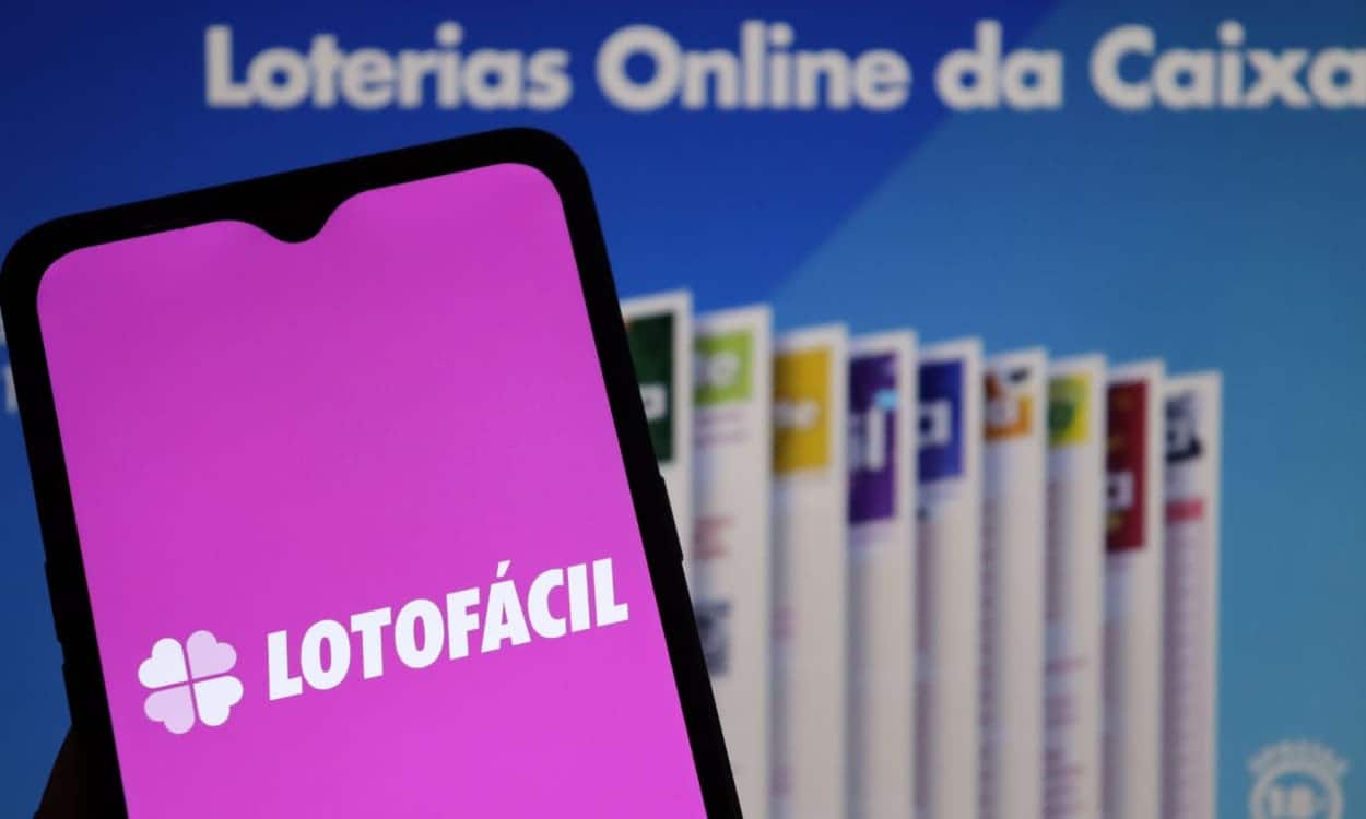 Celular com a logo da Lotofácil na tela.