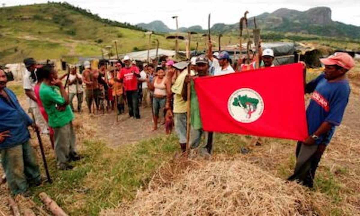 Integrantes do MST com a bandeira do movimento
