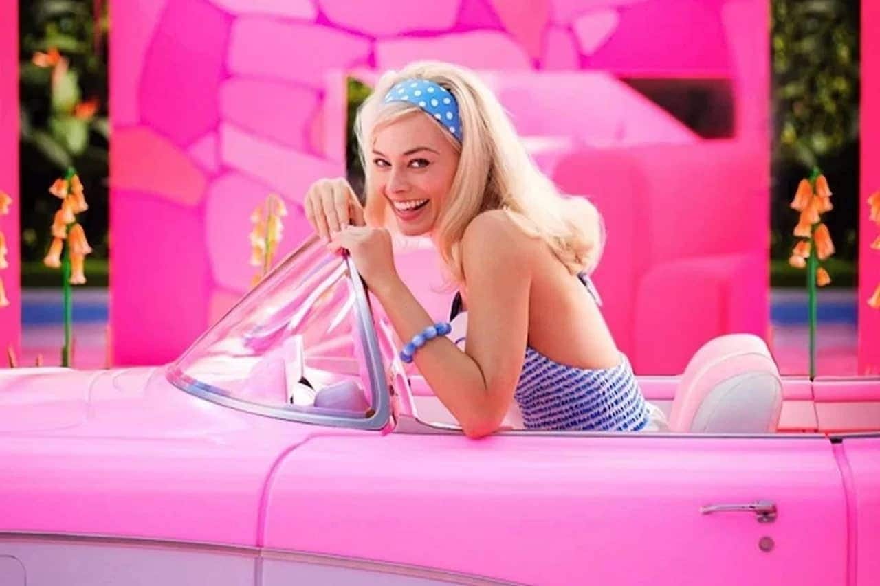 Margot Robbie em carro rosa numa cena do filme Barbie