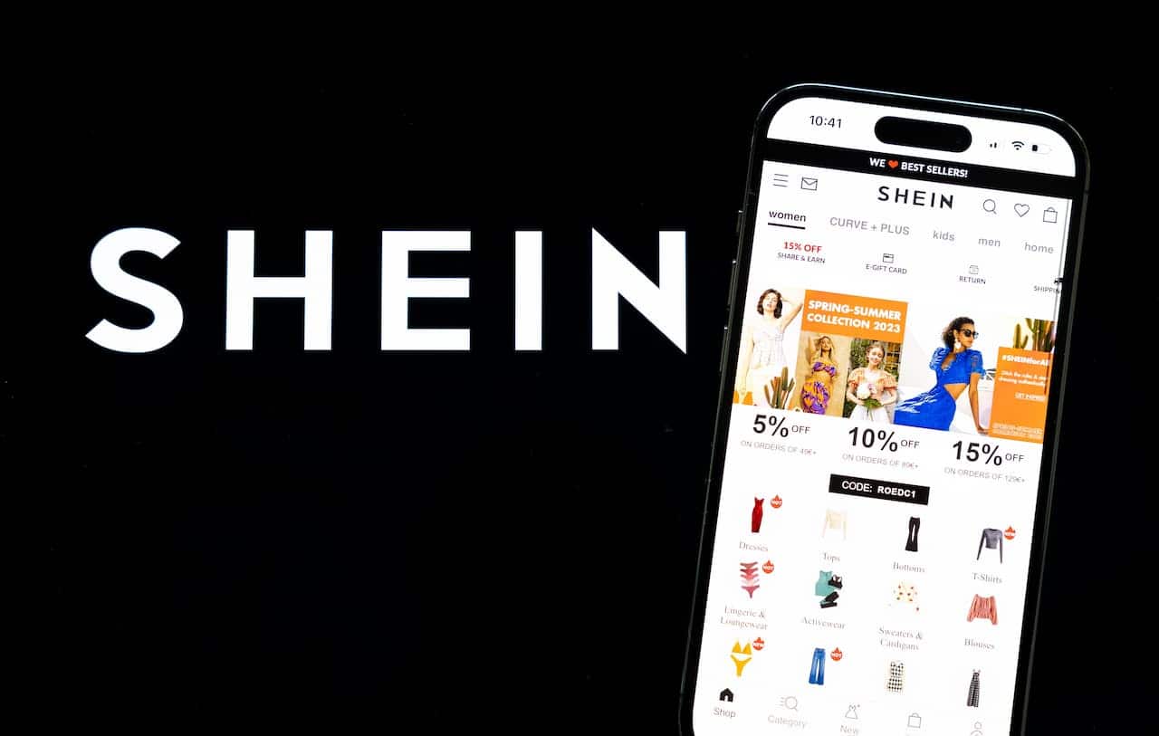 Aplicativo da shein aberto em um celular e ao lado o logotipo da empresa