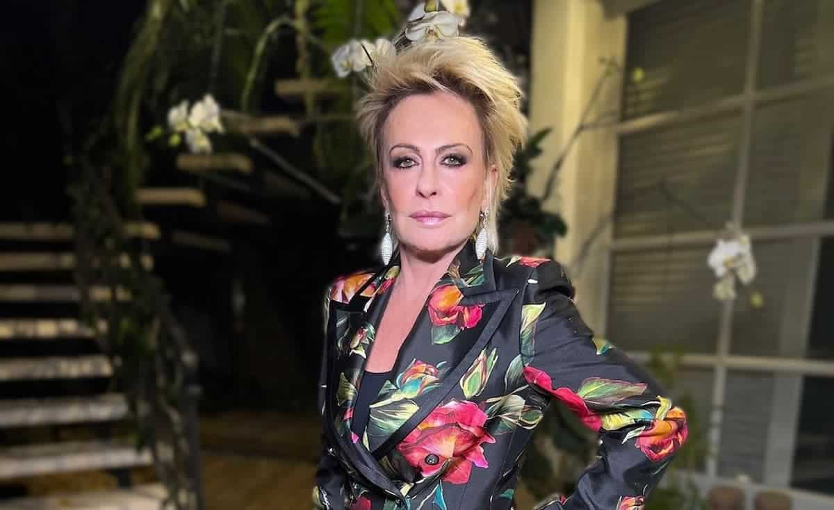 Imagem de Ana Maria Braga posando para foto em frente a uma escada.