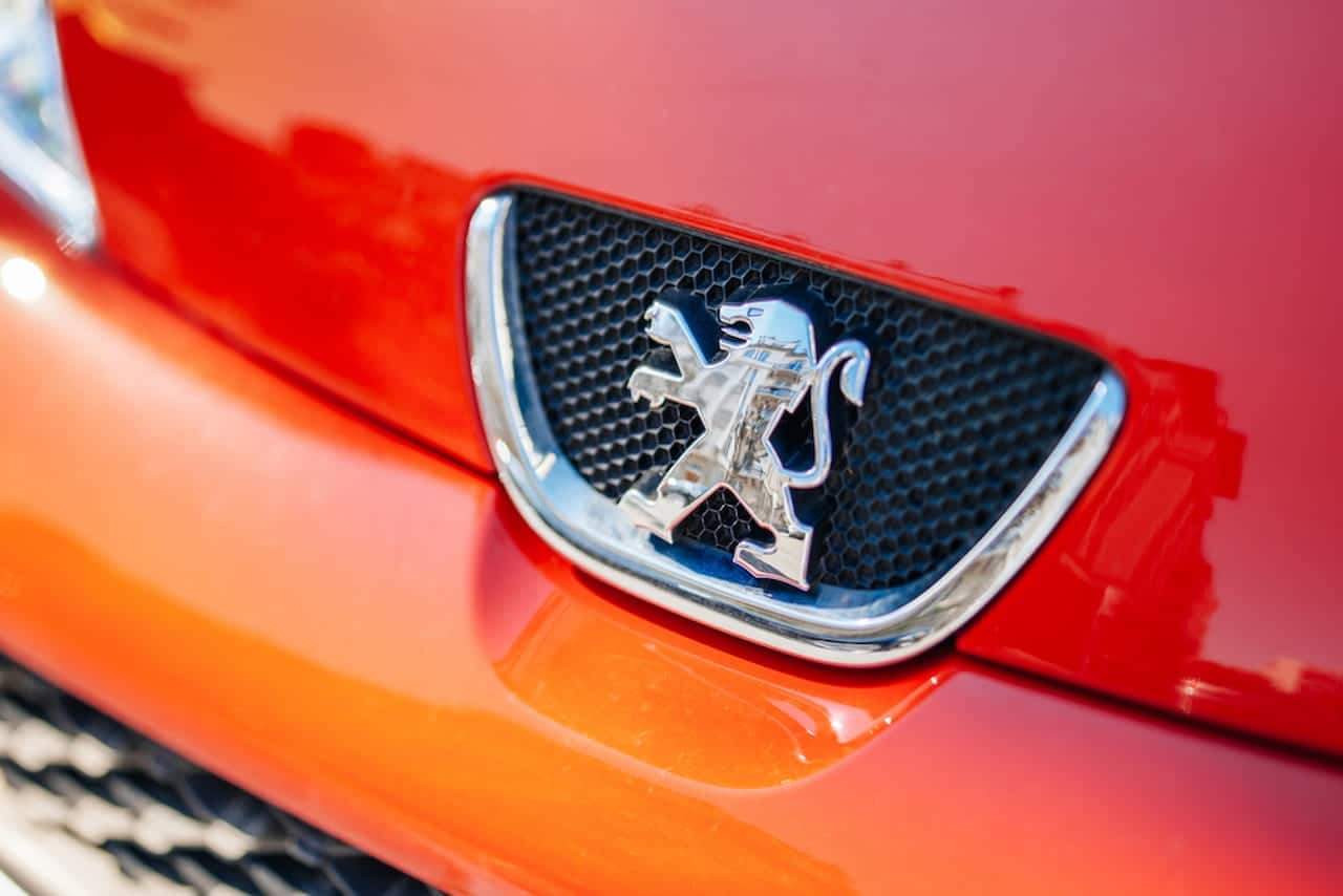Logo da Peugeot em um carro vermelho