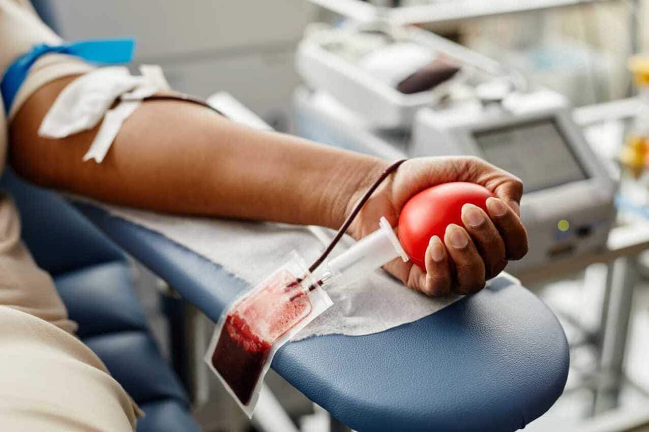 Doador de sangue com braço na cadeira de coleta
