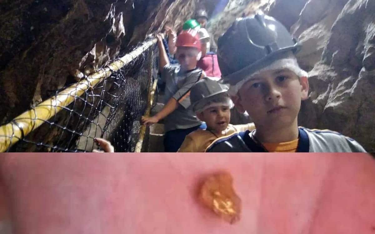 Criança que encontrou a pepita de ouro dentro da mina/ pepita de ouro na mão da criança