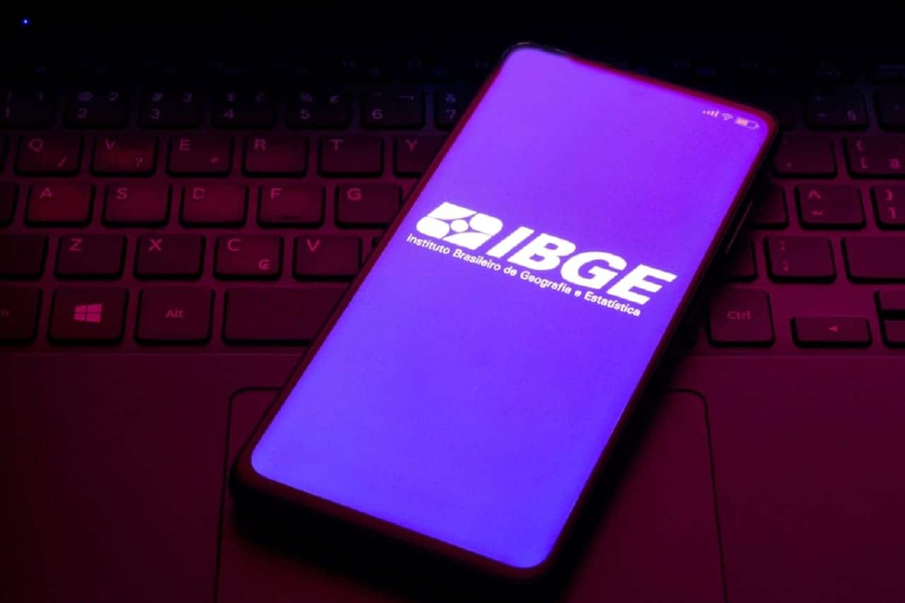 Imagem de um celular com a tela na logo do IBGE