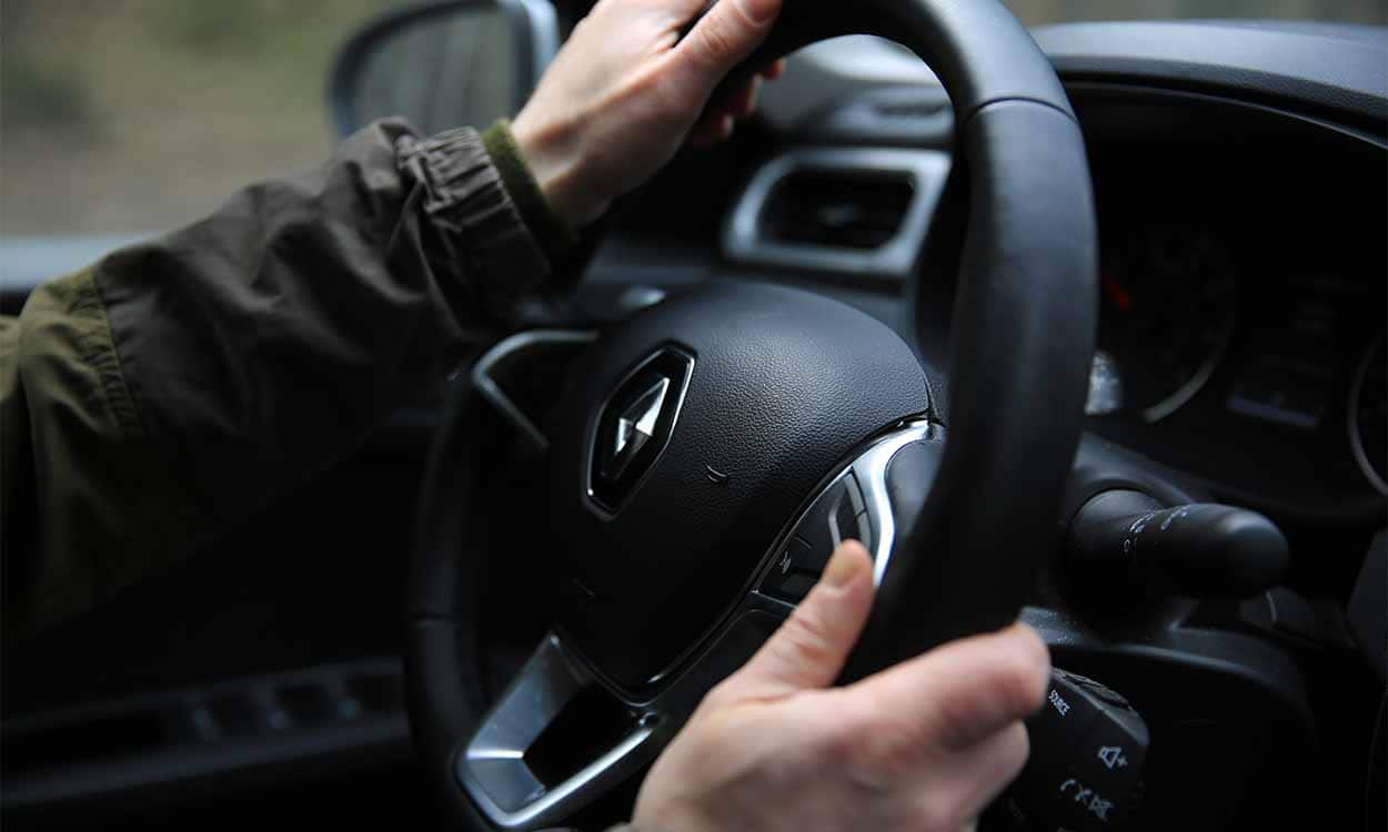 Imagem de homem segurando o volante de um veículo da Renault.