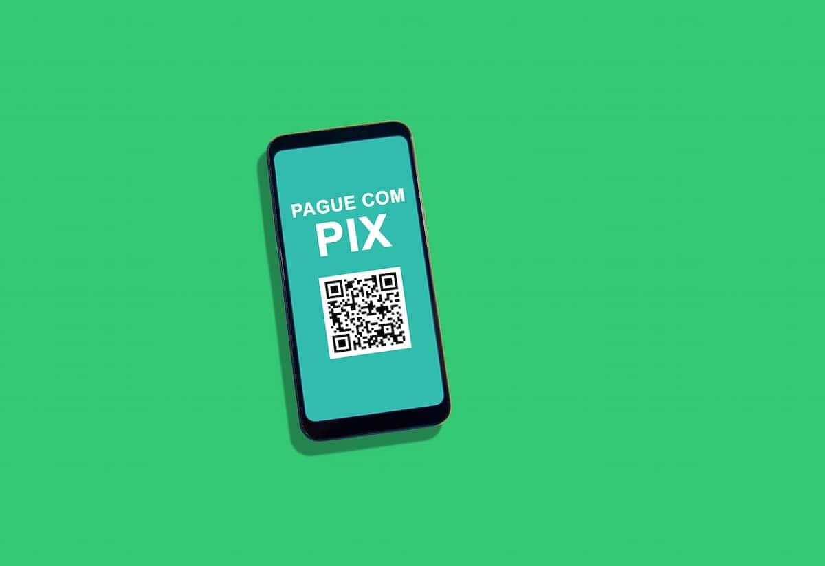 QR code para pagamento através do PIX em celular sobre fundo verde