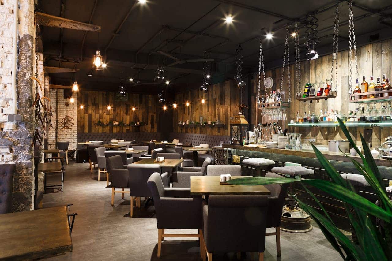Restaurante com diversas mesas e cadeiras.