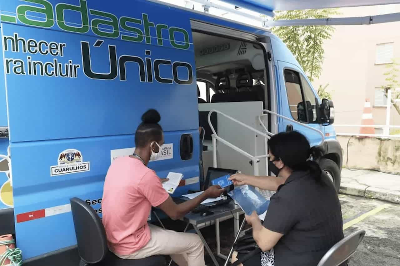 Van do CadÚnico e uma pessoa sendo atendida pelo agente.