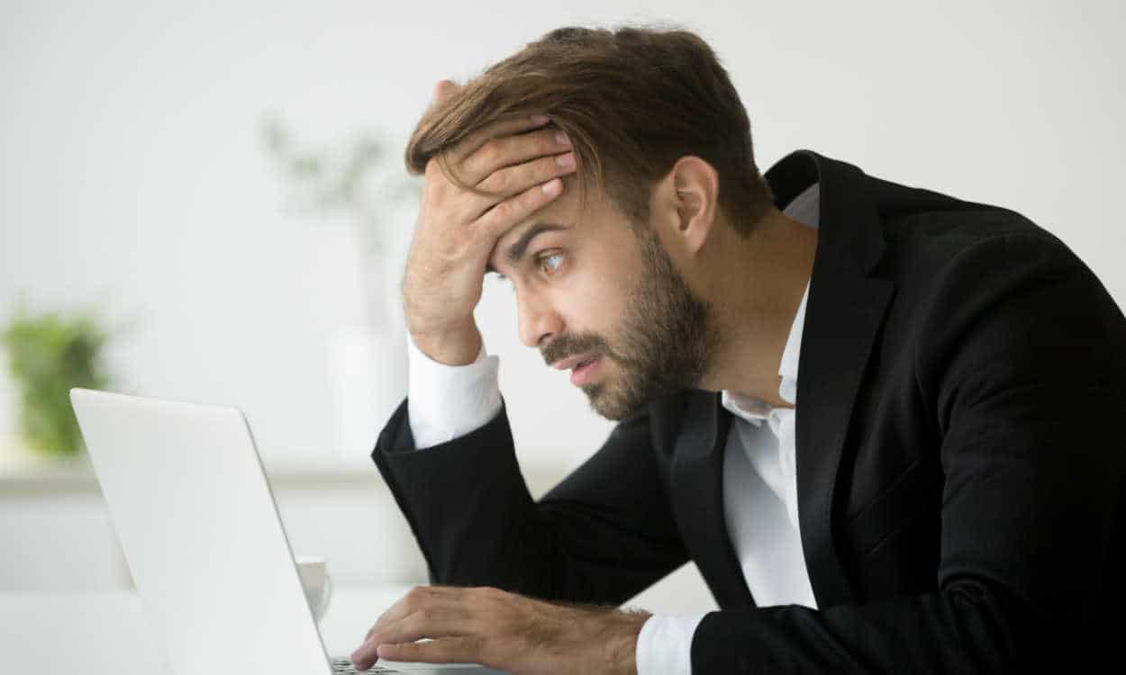 Homem preocupado olhando para a tela do computador