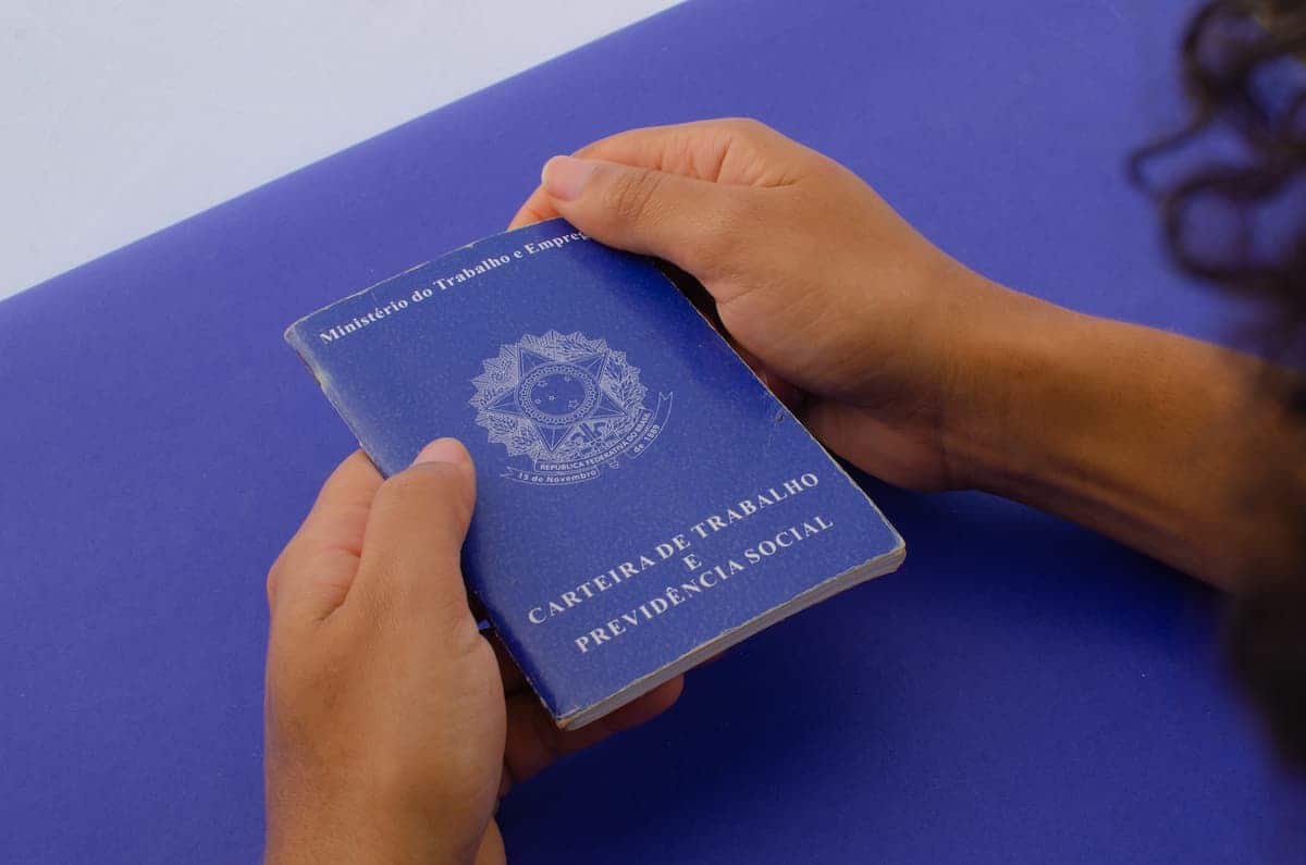 mão com carteira de trabalho bolsa família