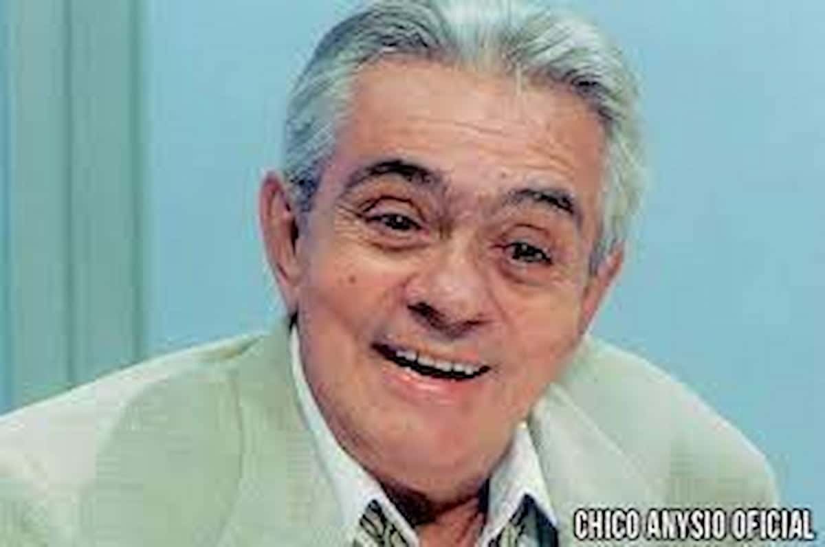 Chico Anysio sorrindo, em fundo azul