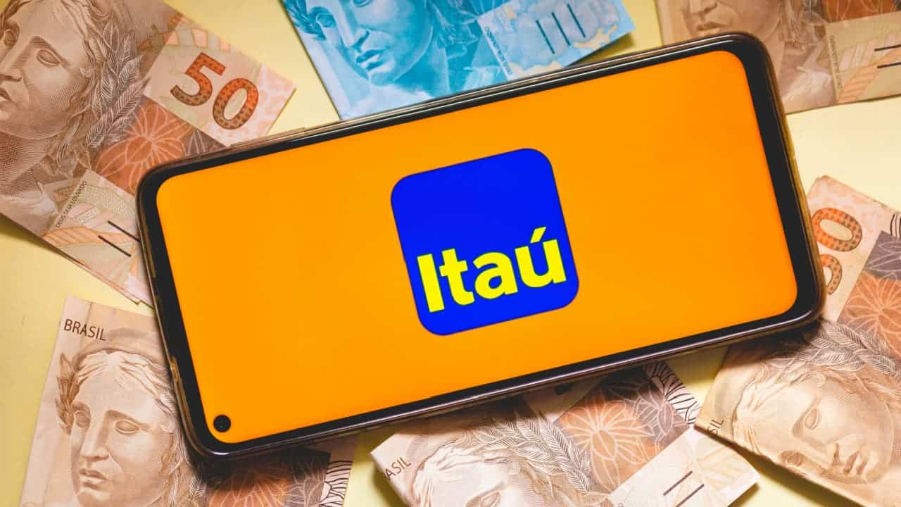Celular com logo Itaú ao redor de cédulas brasileiras.