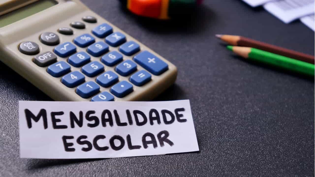 imagem com bilhete escrito 'mensalidade escolar' e ao lado calculadora e lápis