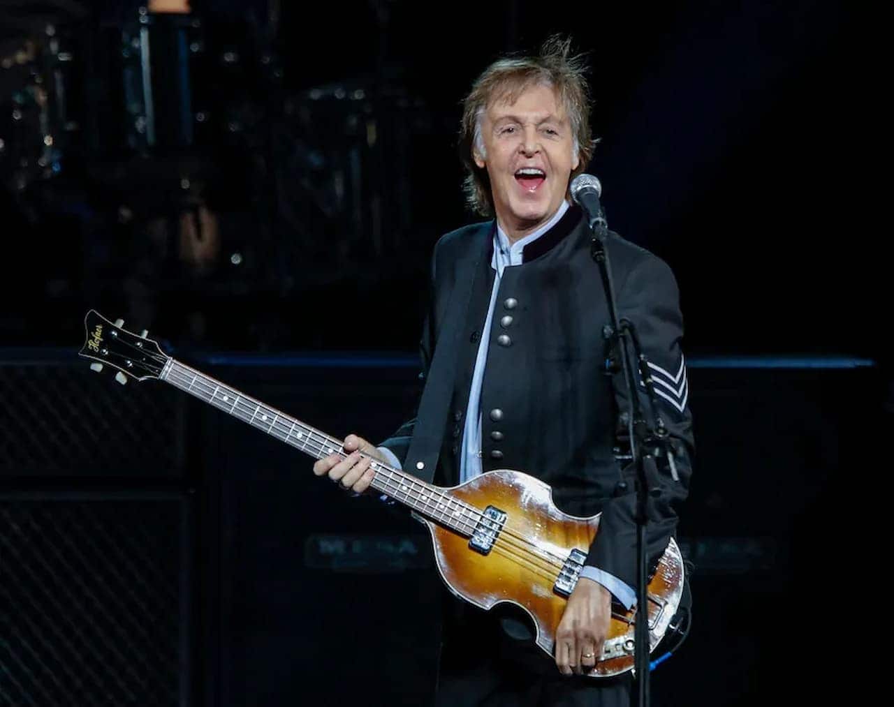 Cantor Paul McCartney no palco durante uma performance.