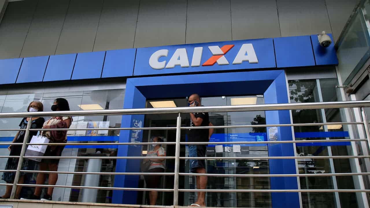 Pessoas em frente a uma unidade da Caixa