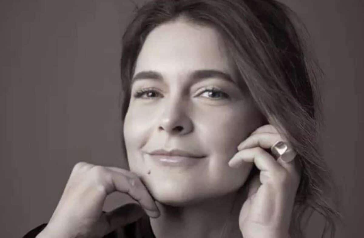 Atriz Cláudia Abreu com as mãos no rosto.