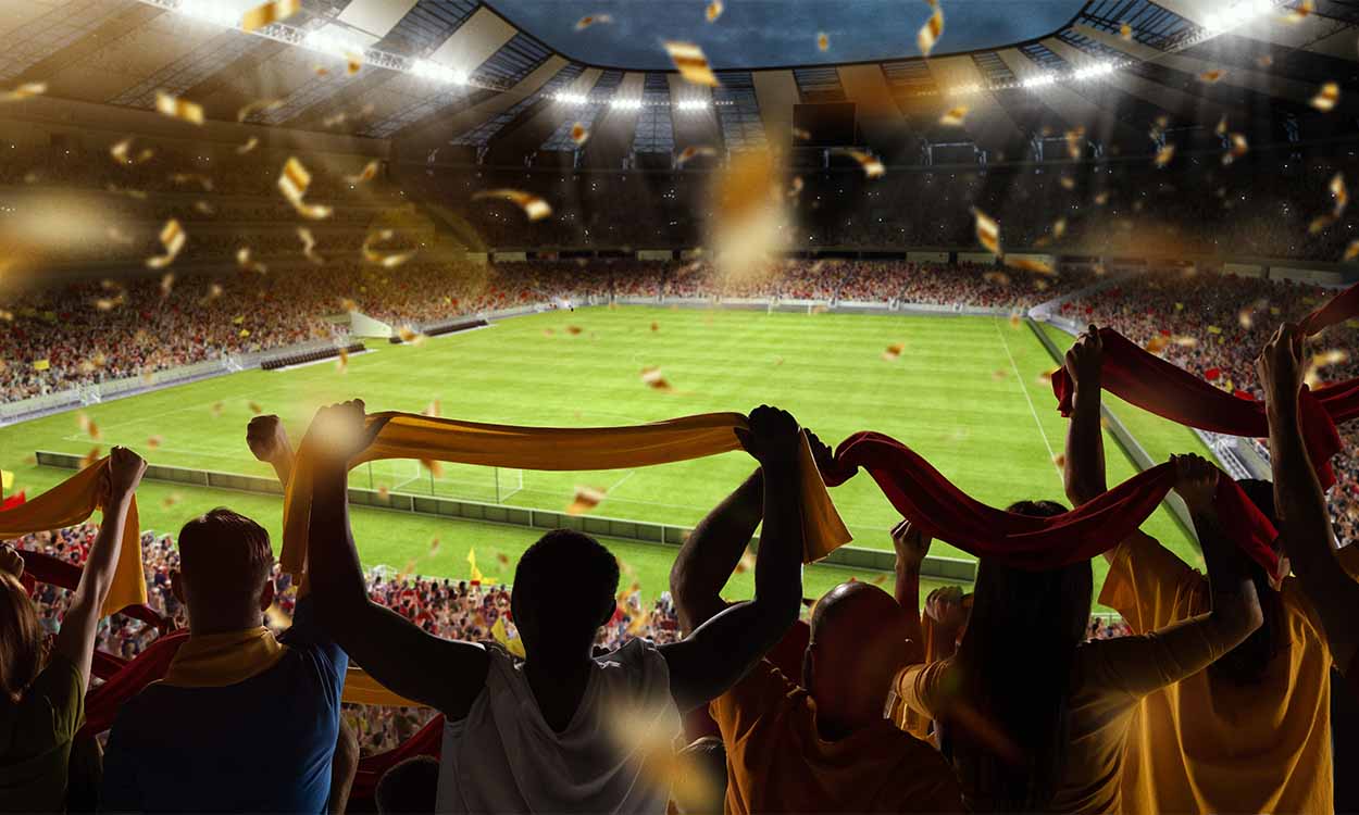 Torcedores torcendo para seus times em um campo de futebol.