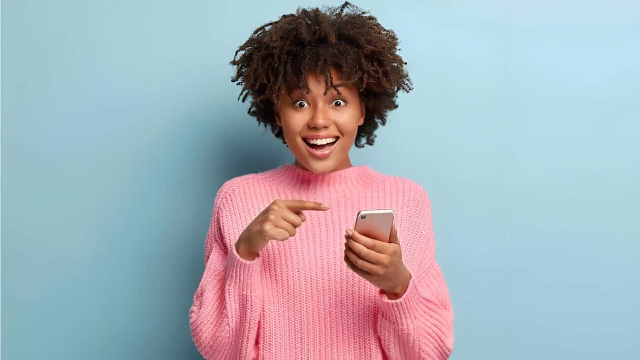 Mulher feliz apontando o dedo para o celular