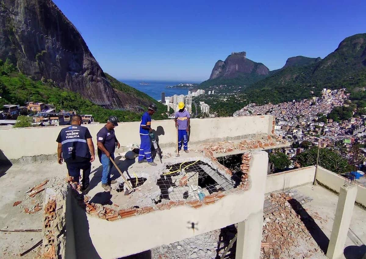 Homens trabalhando em demolição de mansão de traficante na Rocinha, RJ.