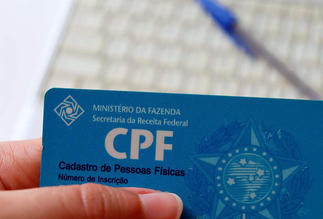 Mão segurando comprovante do CPF