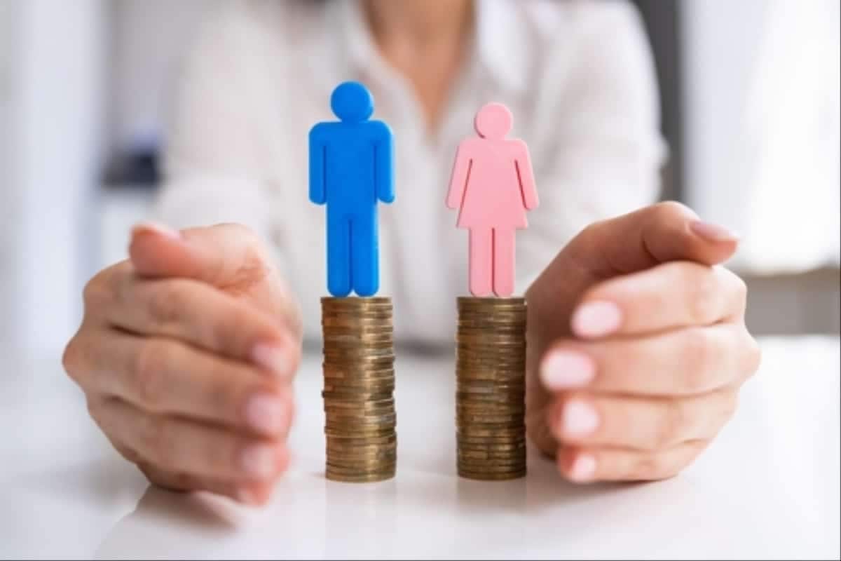 Bonequinhos representanto um homem e uma mulher em cima de pilhas de moedas do mesmo tamanho representando a Lei de Igualdade Salarial