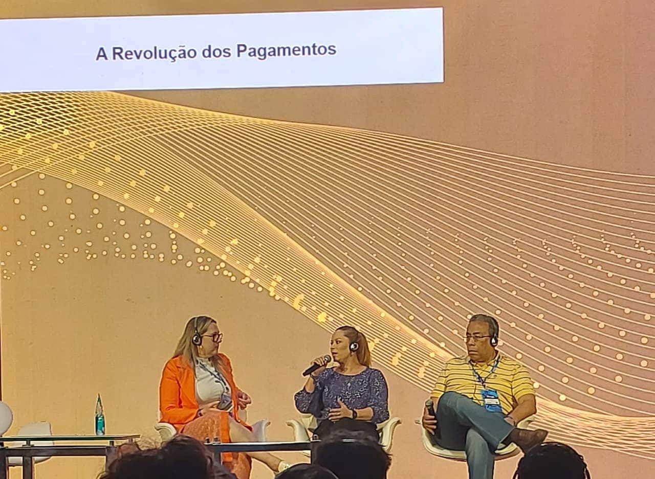 Foto dos três palestrantes participando do evento.