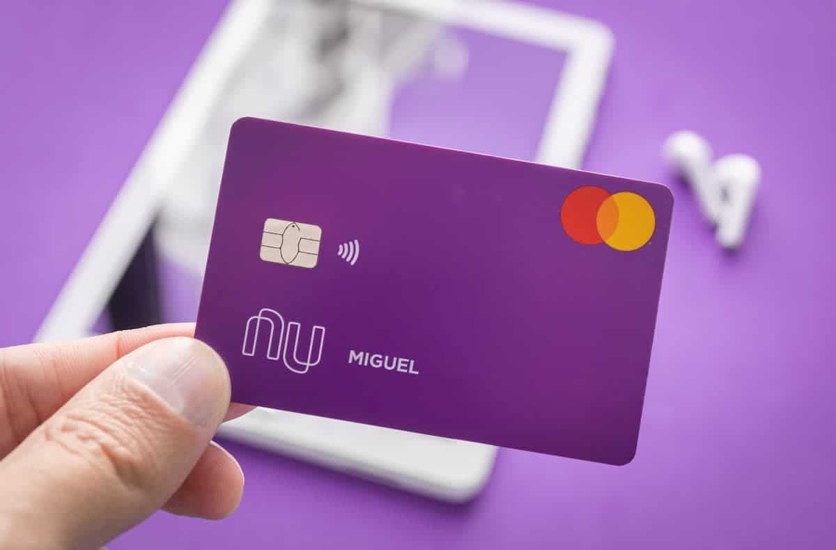 Mão segurando cartão do Nubank