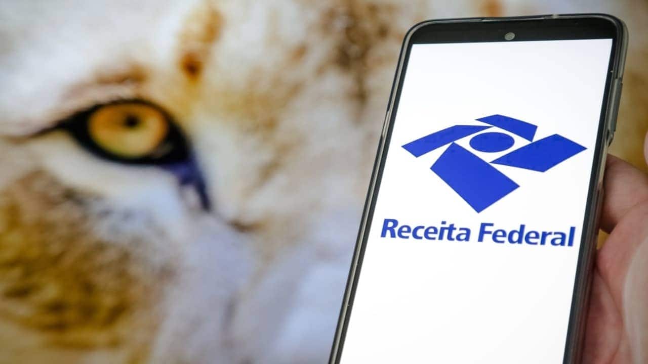 Celular com a logo da Receita Federal e leão atrás, representando o carnê-leão