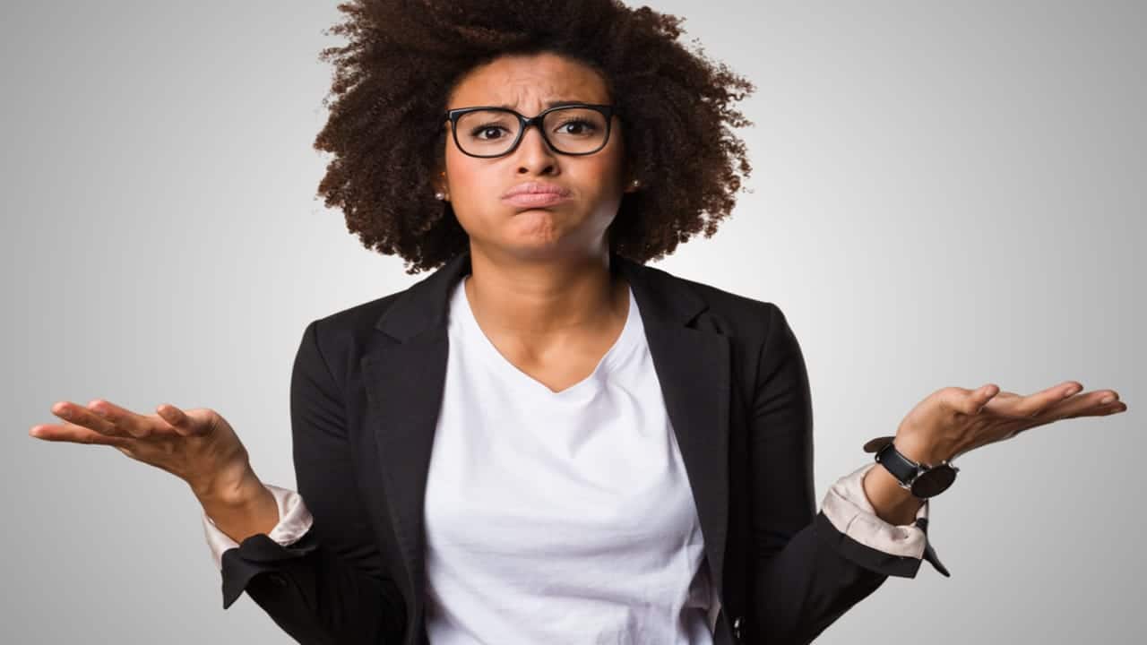 Mulher negra com roupa executiva e expressão de confusa