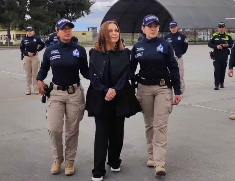 Designer Nancy Gonzalez sendo escoltada por policiais.