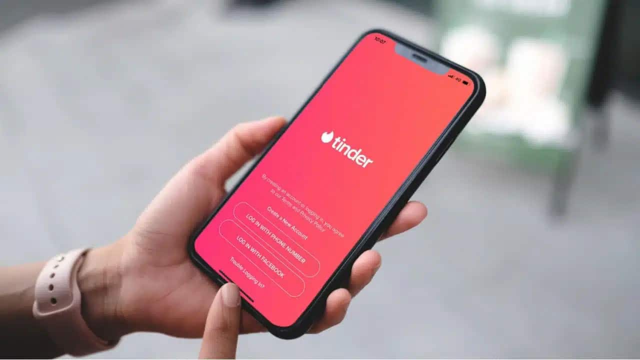 mão segurando celular aberto no aplicativo de relacionamento, Tinder