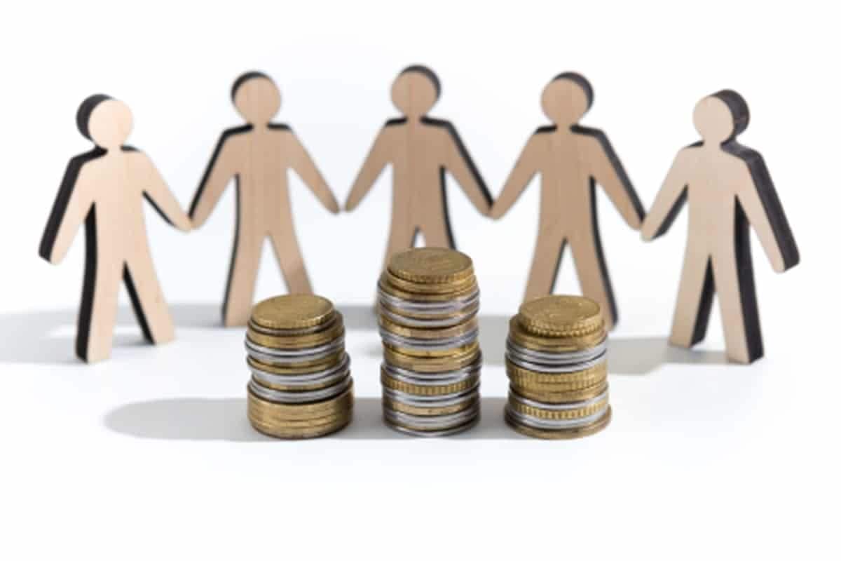 bonequinhos de papel em frente a uma pilha de moedas representando a renda per capita