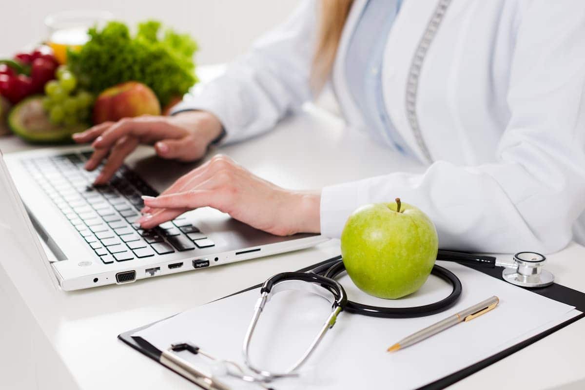 Nutricionista digitando no computador.
