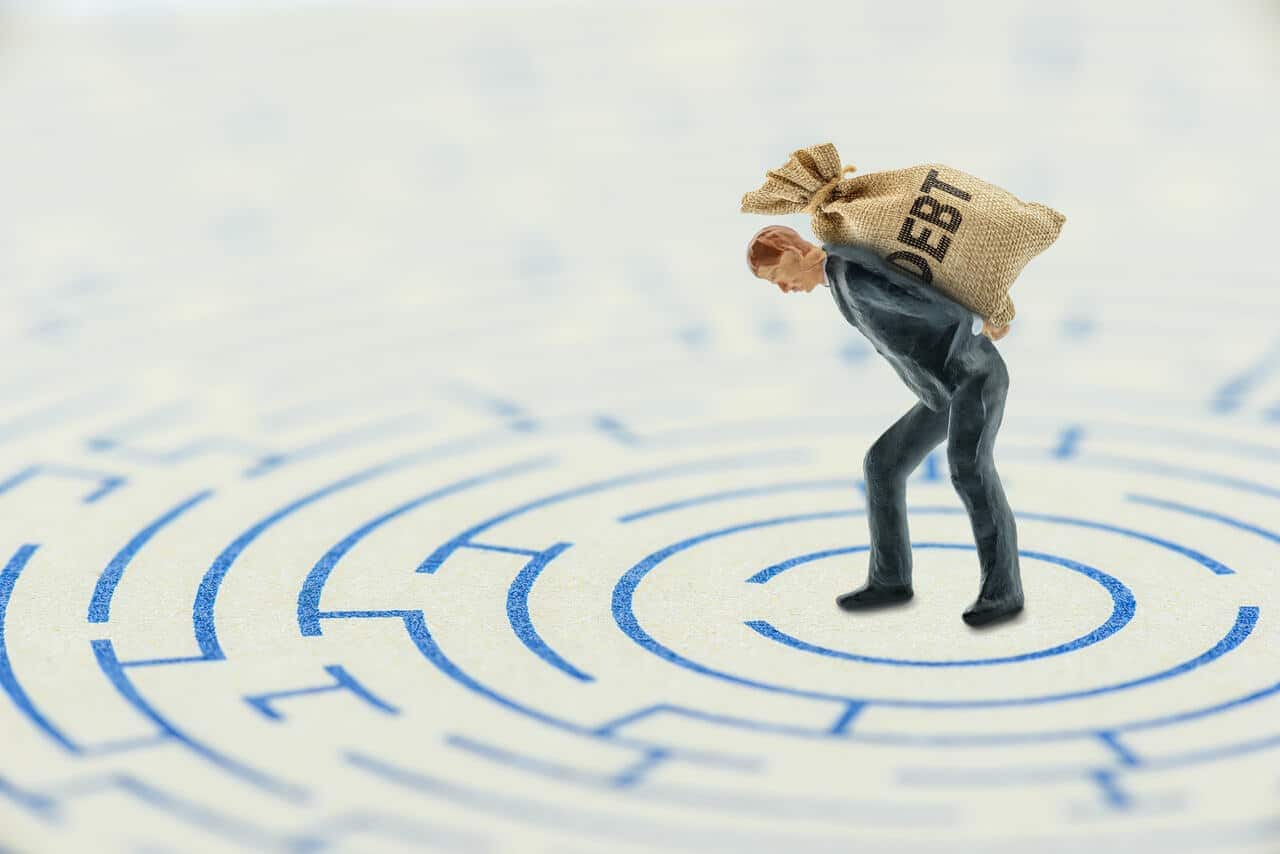 Homem curvado com um saco nas costas escrito "Debt"