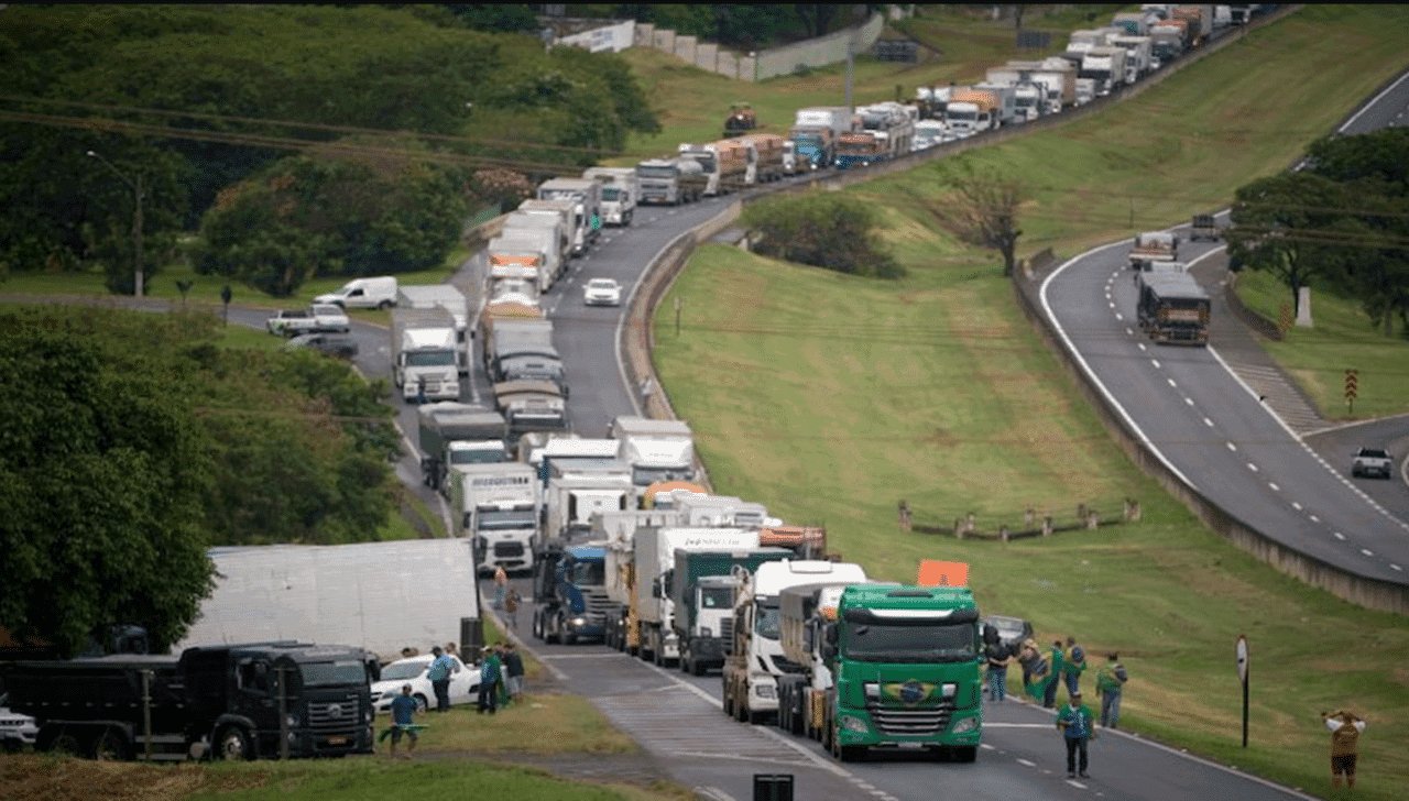 imagem mostra diversos carros e caminhões enfileirados em uma rodovia congestionada