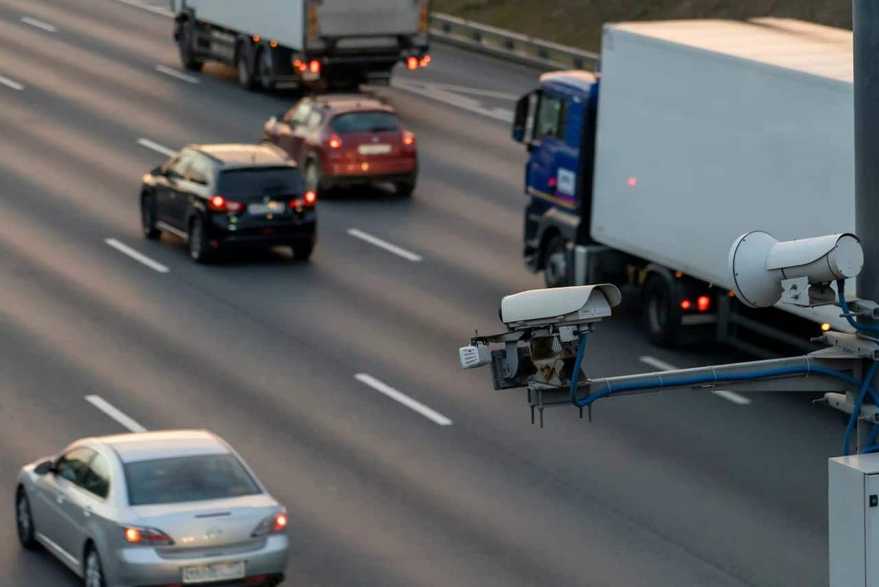 Via com diversos carros transitando e radar